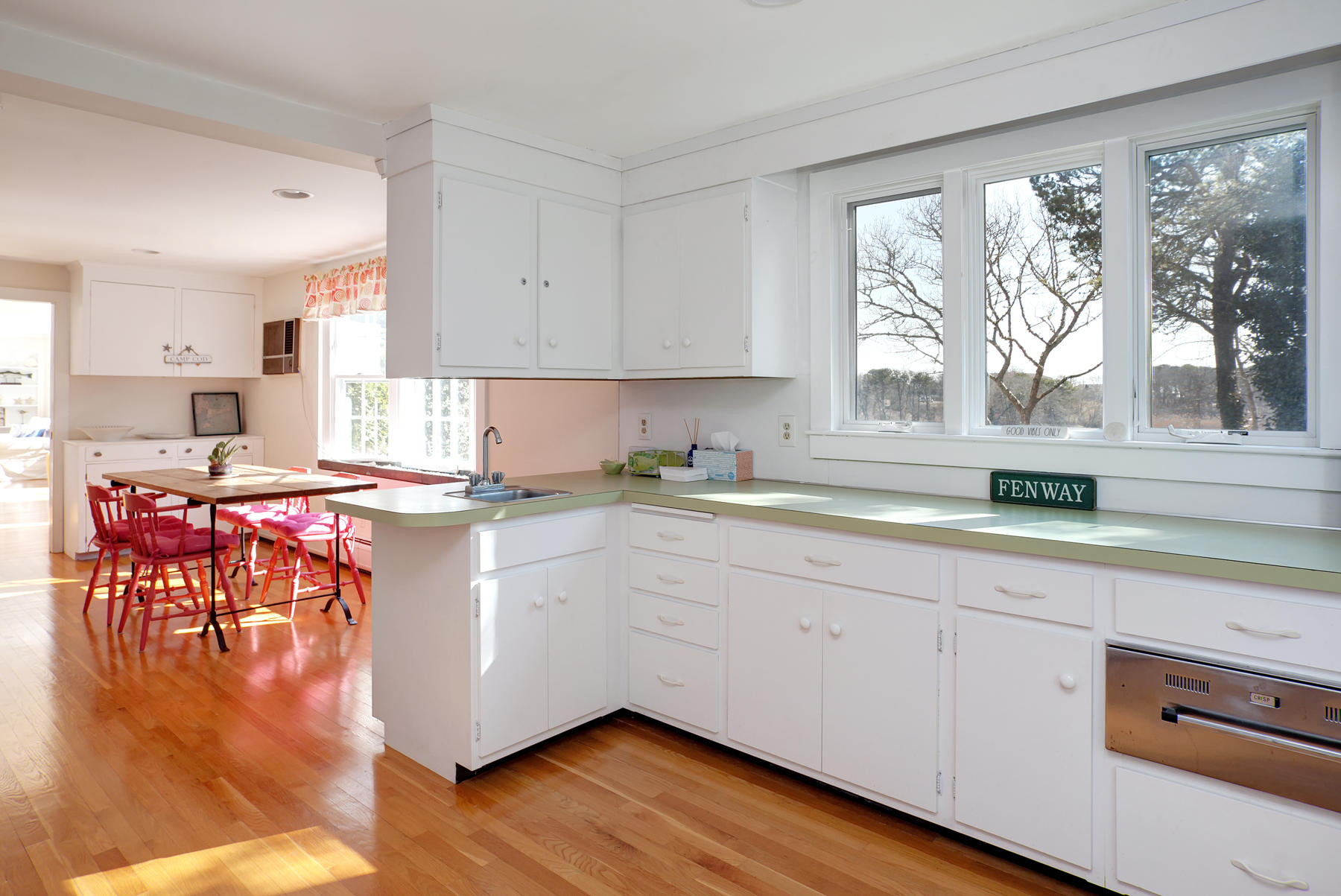 247 Crystal Lake Road Osterville, MA 02655 - Photo 26 of 34 a open kitchen with granite countertop a stove top oven a sink a dining table and chairs with wooden floor