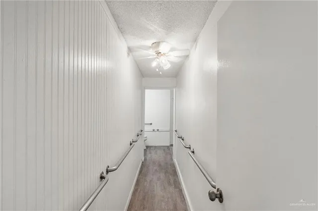 a view of a hallway with wooden floor