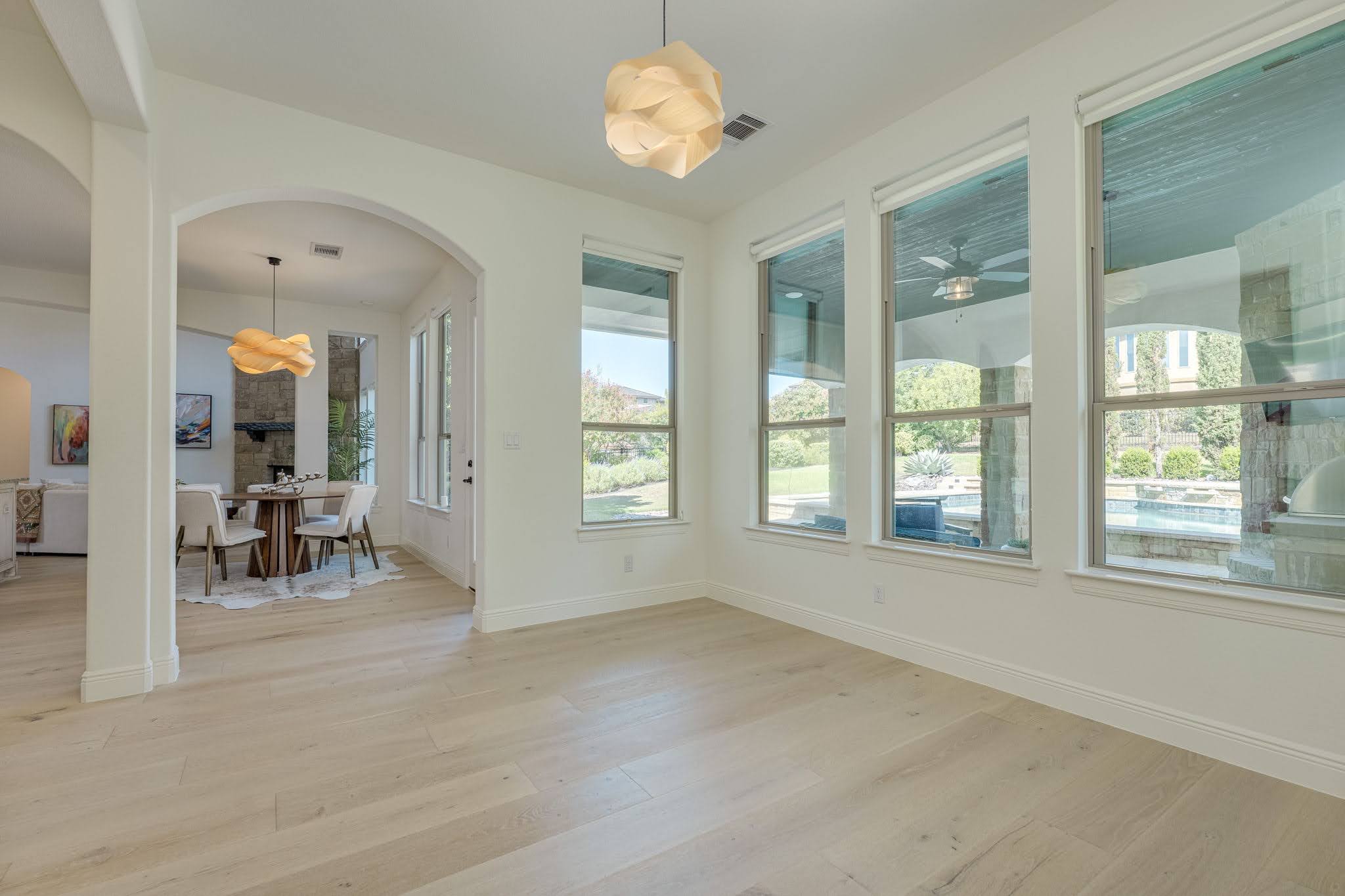 11612 Shoreview Overlook Austin, TX 78732 - Photo 21 of 40 Sunlight streams through large windows onto light wood flooring in this open living space.
