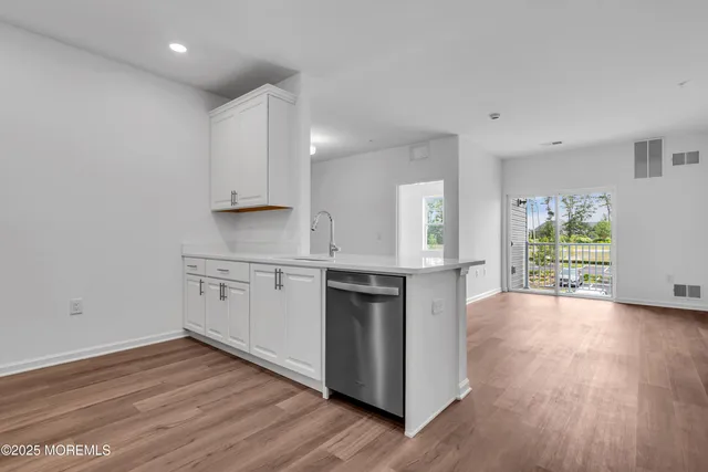 a kitchen with granite countertop a stove and a wooden floors