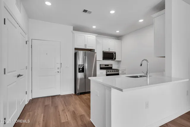 a kitchen with kitchen island a sink stainless steel appliances and refrigerator
