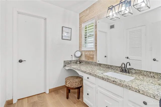 a bathroom with a granite countertop sink a toilet and a mirror