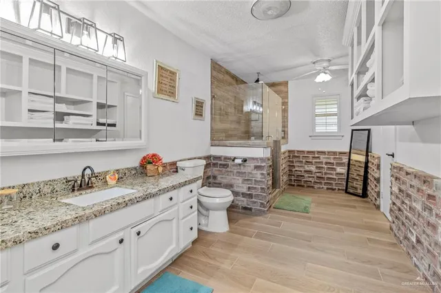 a spacious bathroom with double sink a toilet a mirror and shower