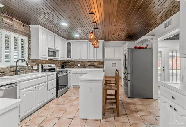 a kitchen with stainless steel appliances a refrigerator sink and cabinets