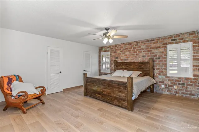 a bed sitting in a room next to a lamp and a chandelier