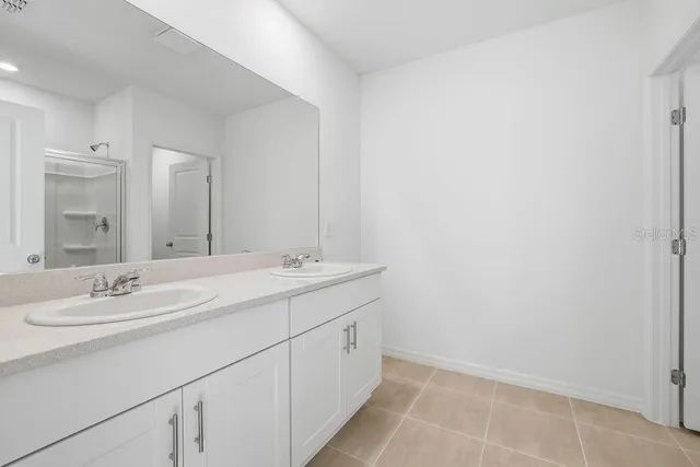 a bathroom with a double vanity sink and mirror
