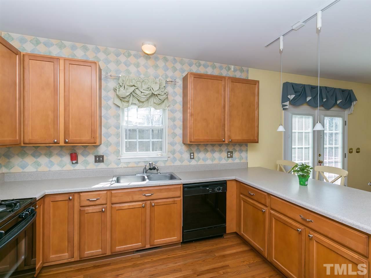 2520 Spruce Shadows Lane Raleigh, NC 27614 - Photo 7 of 25 a kitchen with stainless steel appliances wooden cabinets a sink and a stove