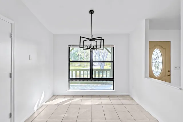 a kitchen with stainless steel appliances granite countertop a refrigerator a sink dishwasher a stove and a dining table with wooden floor