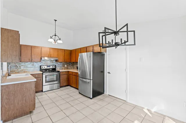 a kitchen with stainless steel appliances granite countertop a refrigerator sink and cabinets