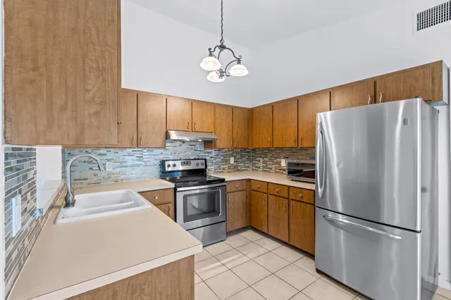 a kitchen with cabinets and stainless steel appliances