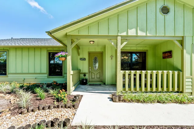 a view of a patio with table and chairs with wooden fence and plants