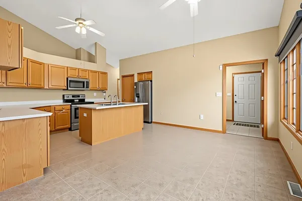 an empty room with windows and fan