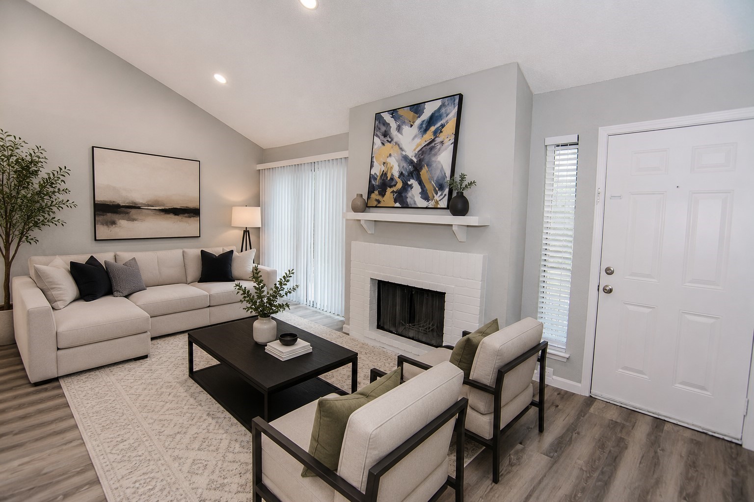 13009 Wirevine Lane Houston, TX 77072 - Photo 7 of 18 Living room features a modern, open space with high ceilings, wood-look floors, and neutral walls. It includes a stylish white brick fireplace, a window with blinds, and a sliding glass door leading to the outside.