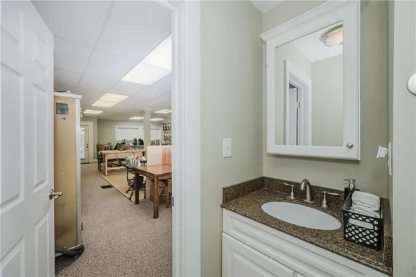 a en suite bathroom with a granite countertop sink and a mirror
