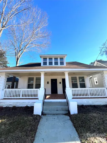 a view of a house with a small yard and furniture