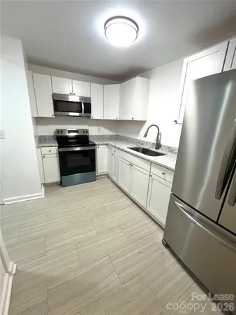 a kitchen with stainless steel appliances a refrigerator sink and microwave