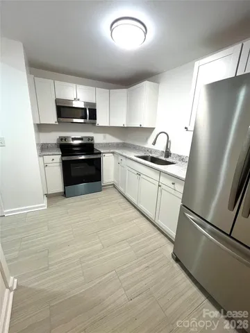a kitchen with stainless steel appliances a refrigerator sink and microwave