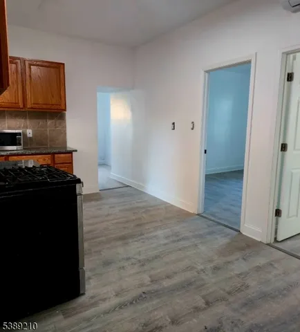 a view of a kitchen with wooden floor and cabinets