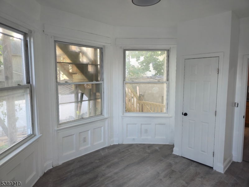 204 Chancellor Avenue, Unit 1 Newark, NJ 07112 - Photo 4 of 6 an empty room with wooden floor and windows