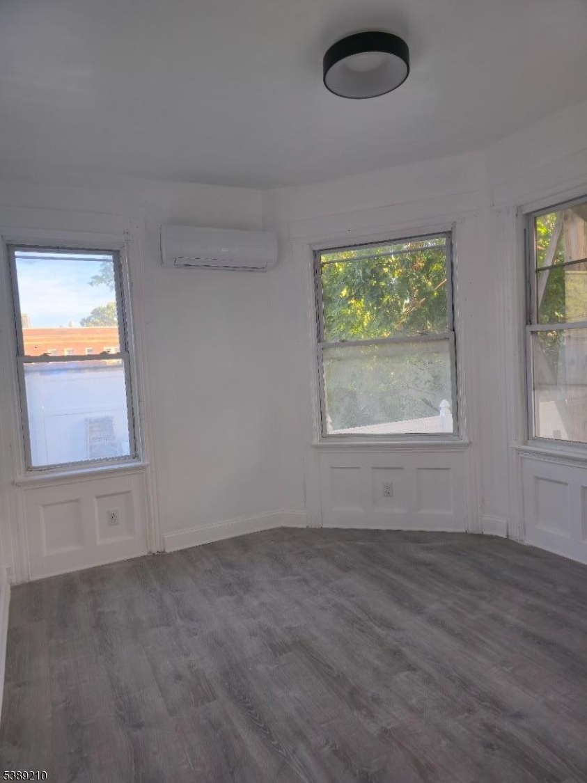 204 Chancellor Avenue, Unit 1 Newark, NJ 07112 - Photo 6 of 6 an empty room with wooden floor and windows