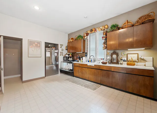 a kitchen with stainless steel appliances kitchen island granite countertop a refrigerator and a stove top oven