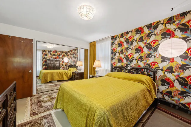 a bed sitting in a bedroom next to a window