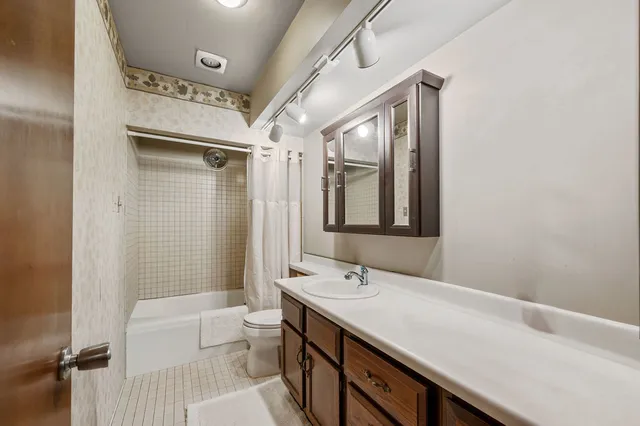 a bathroom with a double vanity sink toilet mirror and bathtub