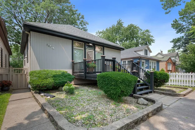 a front view of a house with a yard and potted plants
