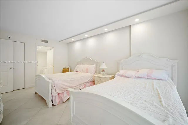 a spacious bedroom with two bed and a couch