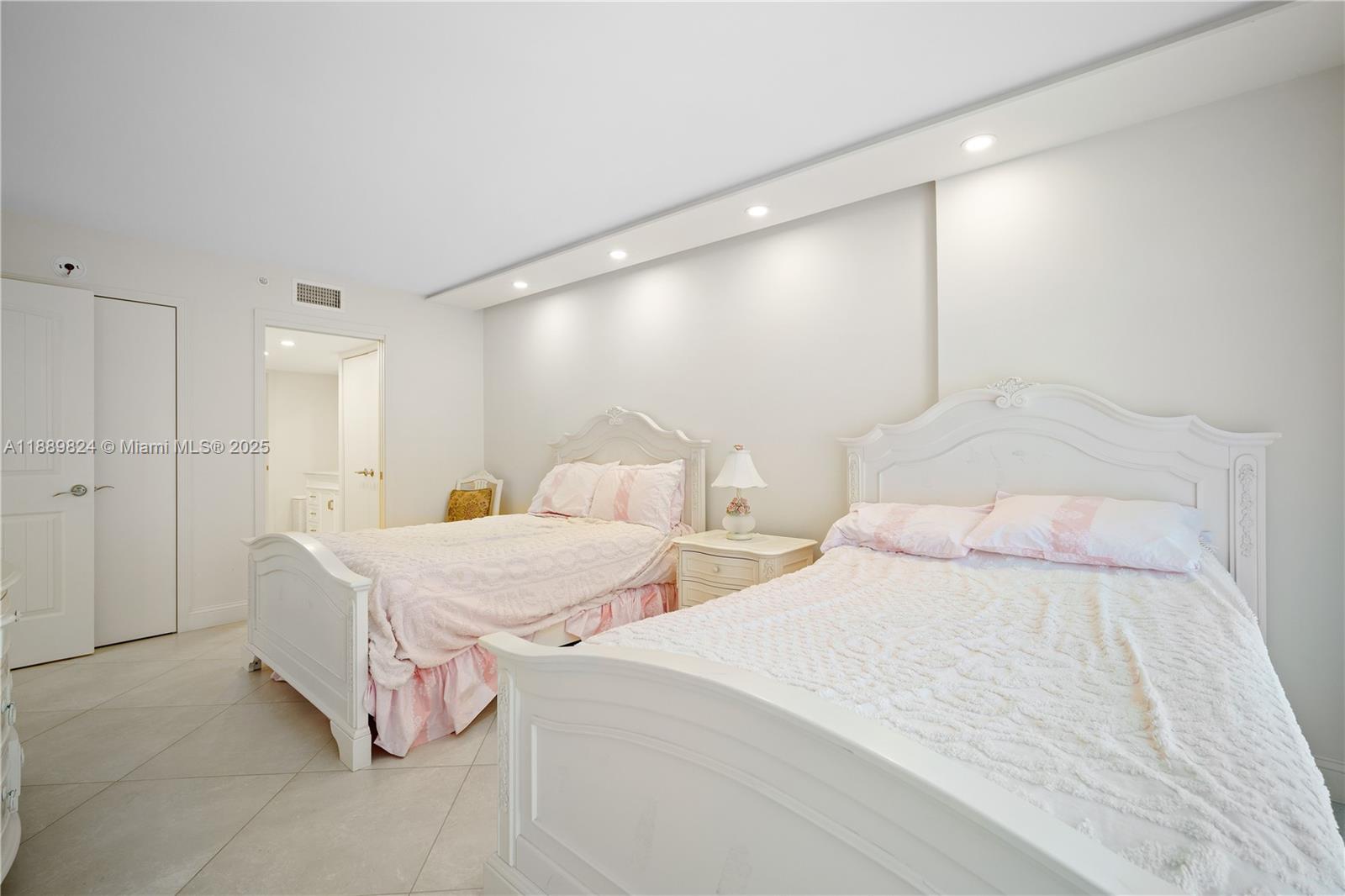 9341 Collins Avenue, Unit 205 Surfside, FL 33154 - Photo 12 of 33 a spacious bedroom with two bed and a couch