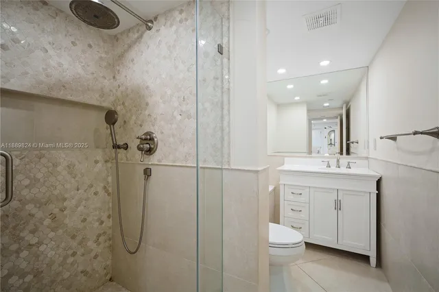 a bathroom with a toilet sink a shower and vanity