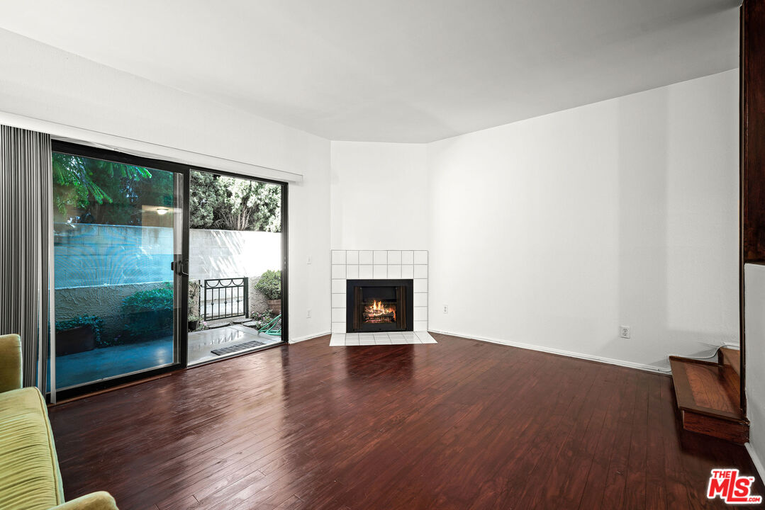 2491 Purdue Avenue, Unit 105 Los Angeles, CA 90064 - Photo 21 of 36 a view of an empty room with wooden floor and a fireplace