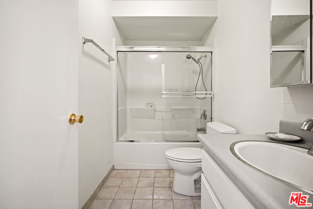 2491 Purdue Avenue, Unit 105 Los Angeles, CA 90064 - Photo 28 of 36 a bathroom with a granite countertop bathtub shower sink mirror and toilet