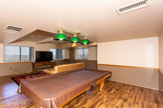a living room with furniture pool table and a flat screen tv