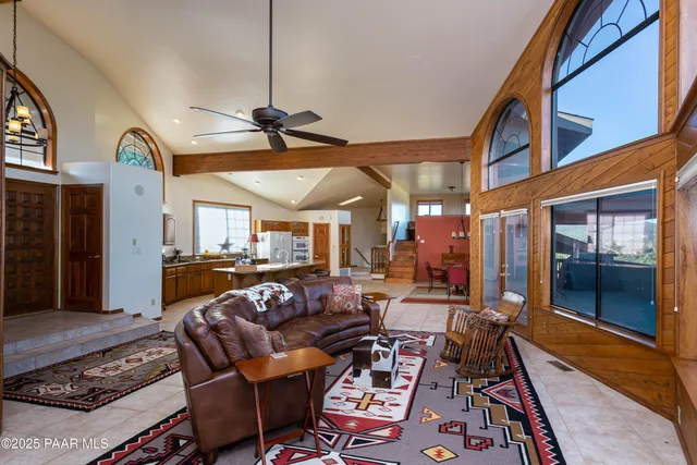a living room with furniture a ceiling fan and a rug