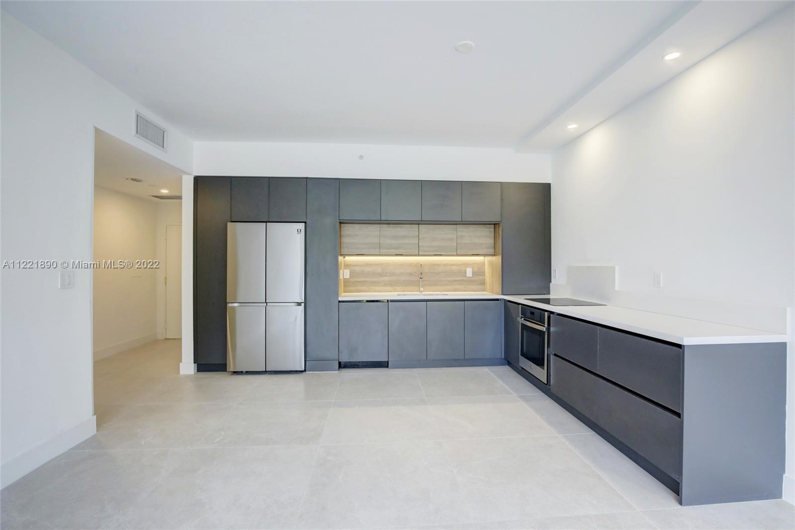 a kitchen with stainless steel appliances a refrigerator and a window