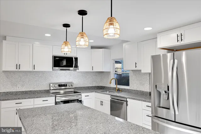 a kitchen with stainless steel appliances a stove center island refrigerator and cabinets