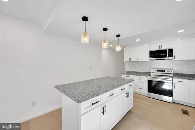 a kitchen with stainless steel appliances granite countertop a sink and a stove