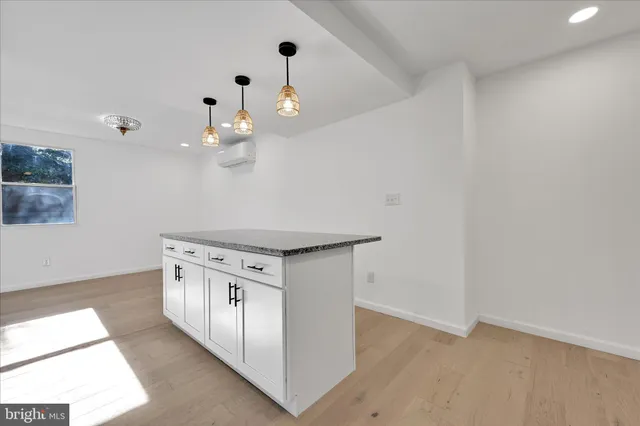 a kitchen with cabinets and wooden floor