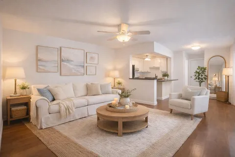 a living room with furniture and a view of kitchen