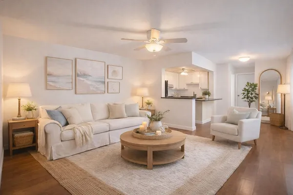 a living room with furniture and a view of kitchen