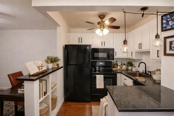a kitchen with stainless steel appliances granite countertop a sink a stove a refrigerator a washer and dryer