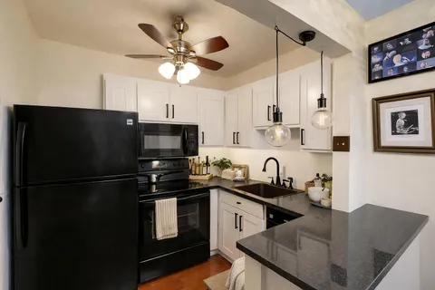 a kitchen with a refrigerator a sink and cabinets