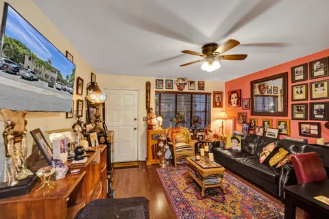 a living room with patio furniture and a chandelier