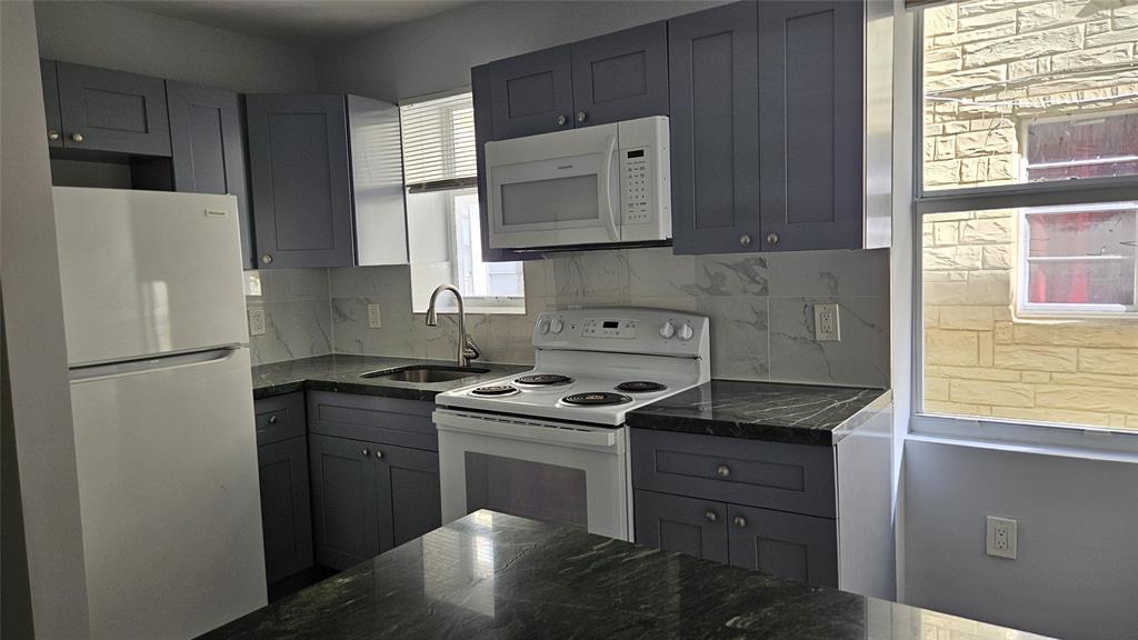 1142 Southwest 4th Street, Unit 3 Miami, FL 33130 - Photo 5 of 17 a kitchen with granite countertop a sink stove and refrigerator