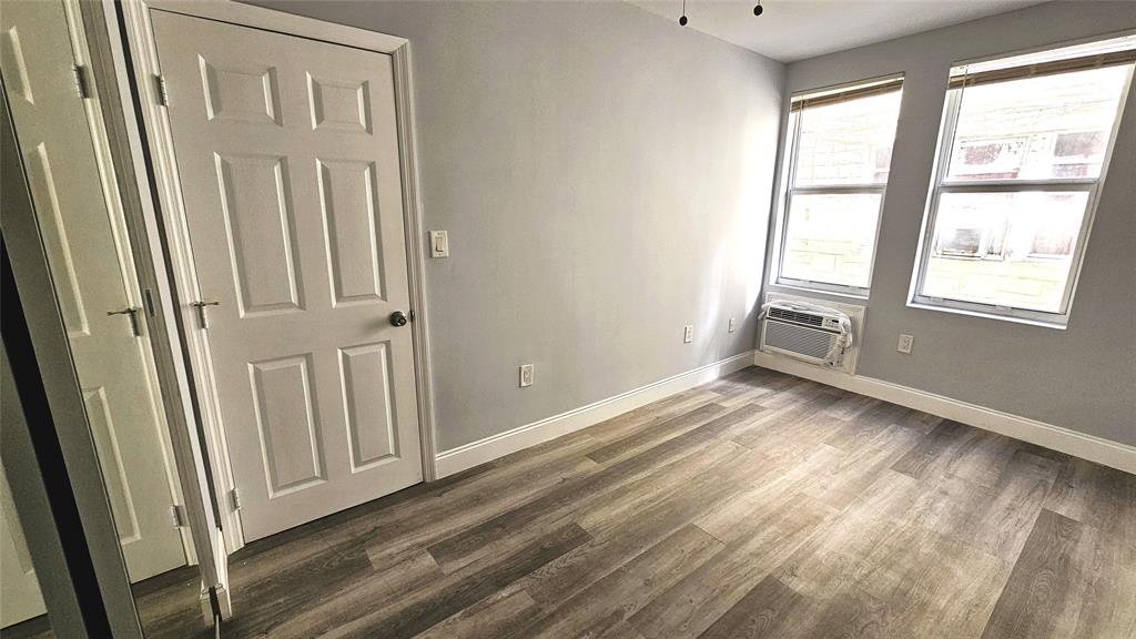 1142 Southwest 4th Street, Unit 3 Miami, FL 33130 - Photo 8 of 17 an empty room with wooden floor and a window