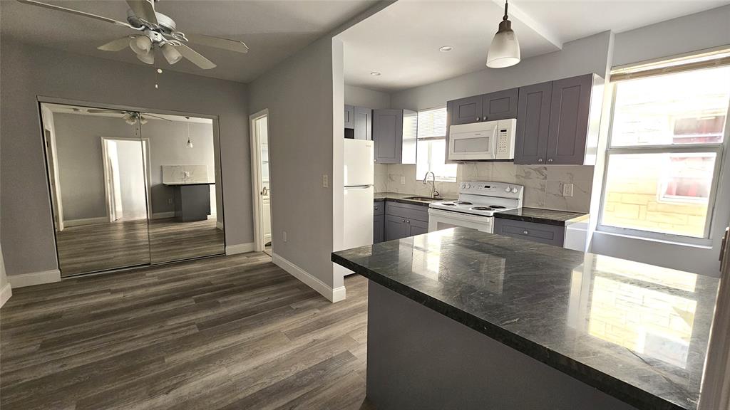 1142 Southwest 4th Street, Unit 3 Miami, FL 33130 - Photo 10 of 17 a view of kitchen with kitchen island a sink appliances wooden floor and a window