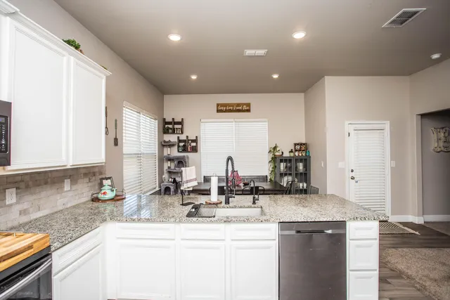 a bathroom with a granite countertop sink a toilet and a mirror