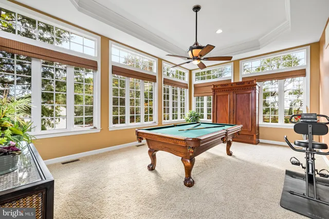a living room with furniture a table and large windows