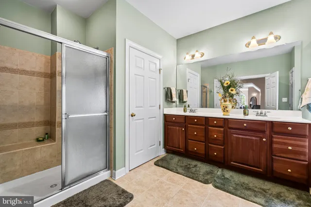 a en suite bathroom with a double vanity sink and a mirror